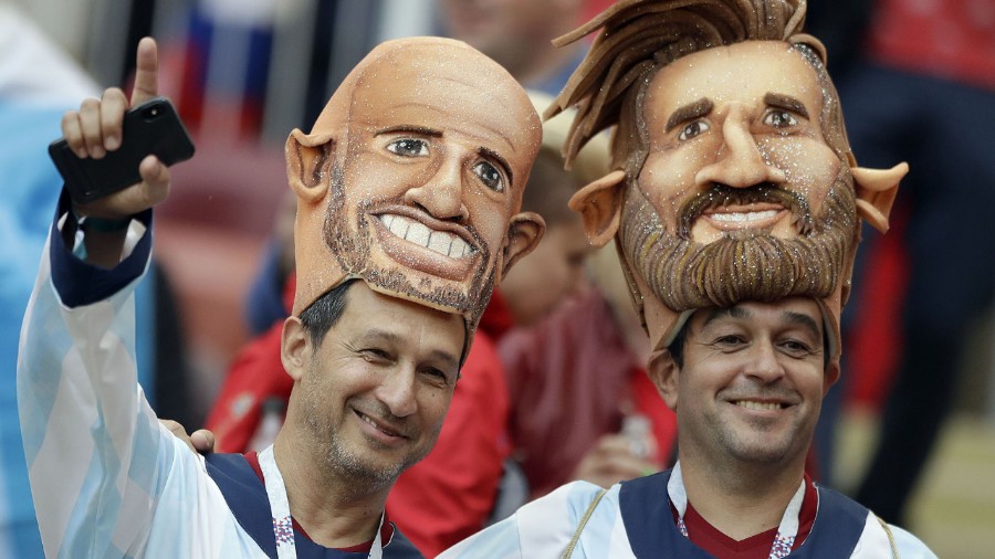 Dos hinchas argentinos en la ceremonia de inauguración del Mundial lucen las caretas de Mascherano y Messi (AP Photo/Matthias Schrader)