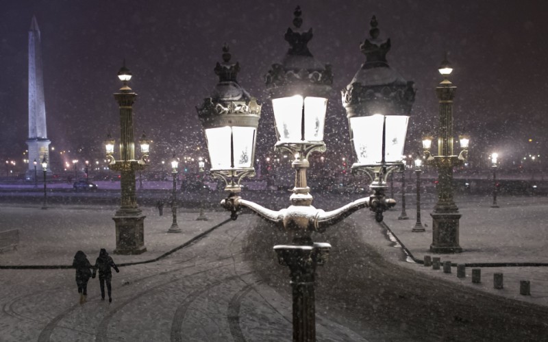 Una pareja camina por la Plaza de la Concordia cubierta por nieve (EFE/Ian Langsdon)